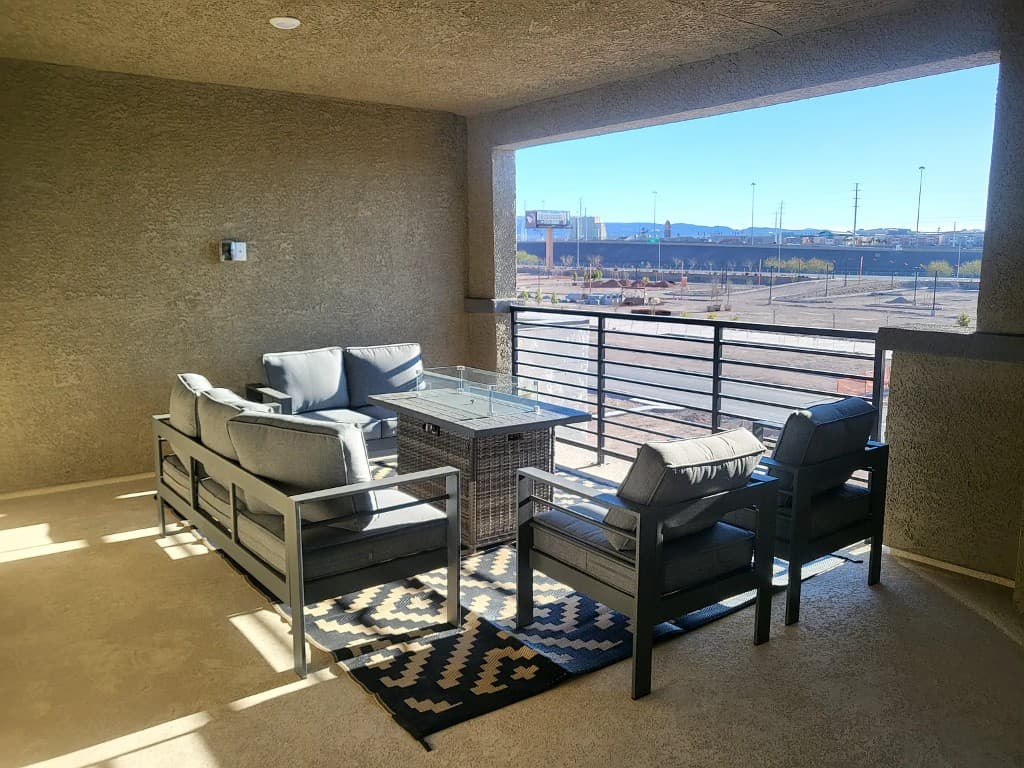 Covered outdoor balcony at 901 Almandine Pl with lounge seating, fire table, and open valley view